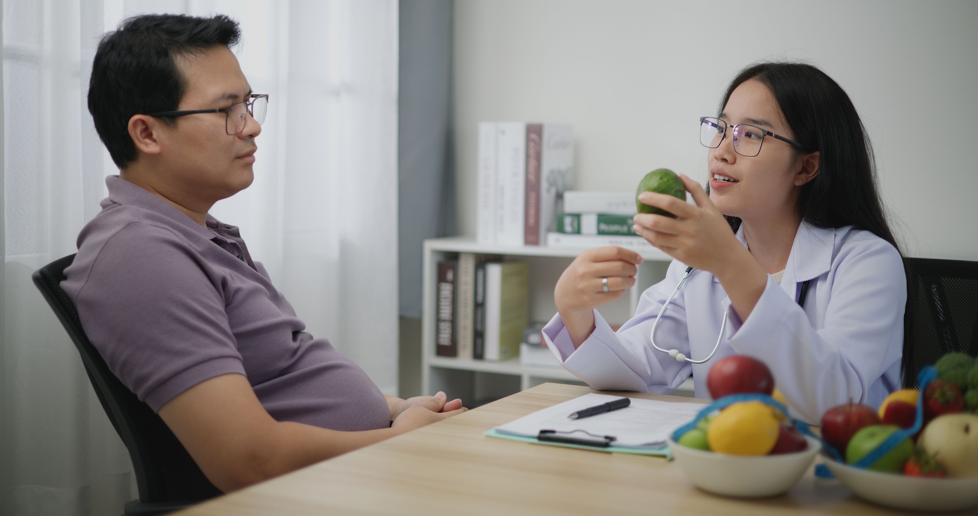 Professional nutritionist asian woman consulting fat man in weight loss clinic